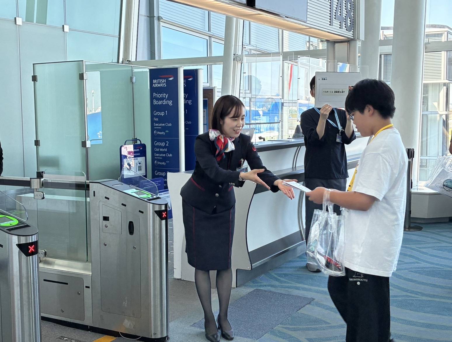 空港の搭乗口で係員に搭乗券を提示する空の旅体験会の参加者